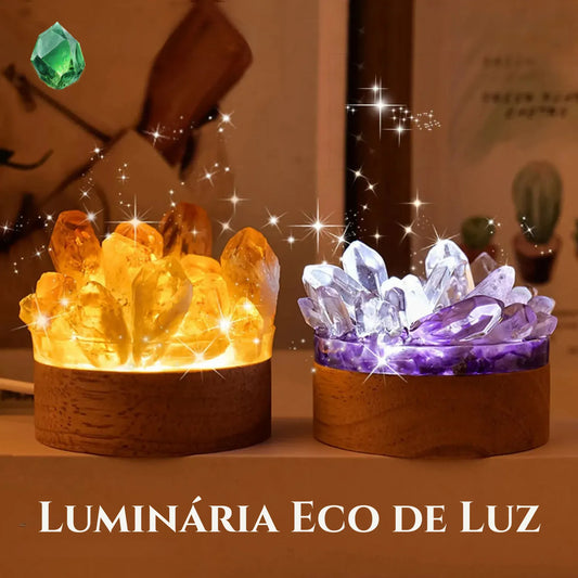 Eco de Luz Perfeita Assimetria -  Duas luminárias de cristais — uma com tonalidade amarela vibrante e outra violeta — iluminadas pela base, criando um efeito de brilho mágico.